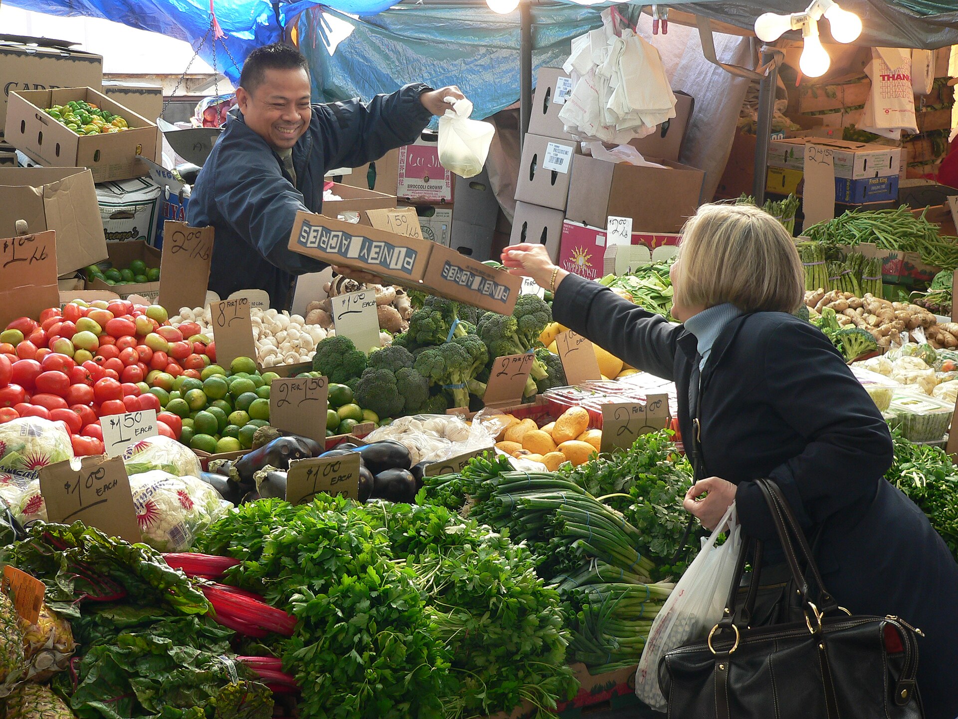 A vendor serving a customer at Haymarket market in Boston