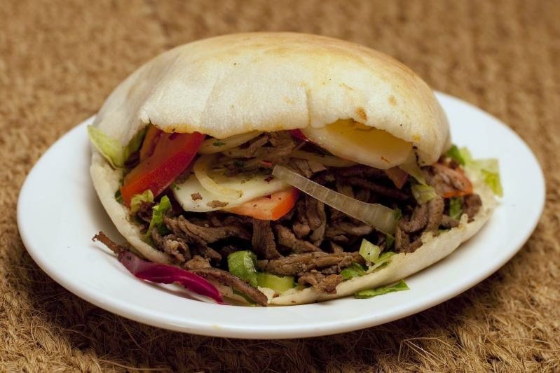 A shawarma sandwich wrapped in paper, ready to eat